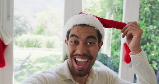 Retrato Jovem Biracial Alegre Papai Noel Gesto Durante Chamada Vídeo — Vídeo de Stock