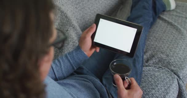 Homem Caucasiano Sentado Sofá Sala Estar Usando Tablet Beber Café — Vídeo de Stock