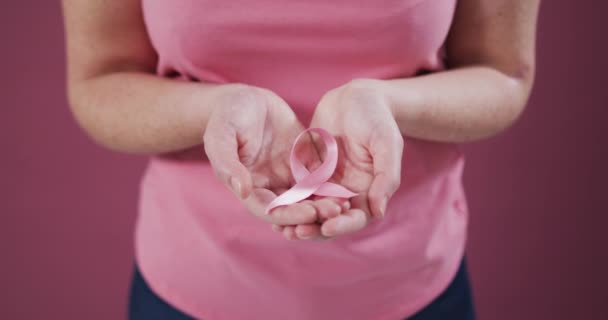 中段妇女手托着粉色乳腺癌意识带 手托着杯子 乳腺癌意识的象征 — 图库视频影像