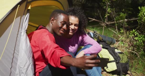 テントに座って田舎で自撮りする多様なカップルを笑顔 健康的で活発なライフスタイルと屋外レジャータイム — ストック動画