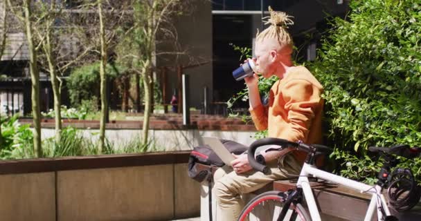 Przemyślany Albinos Amerykanin Dredami Siedzący Parku Pijący Kawę Korzystający Laptopa — Wideo stockowe