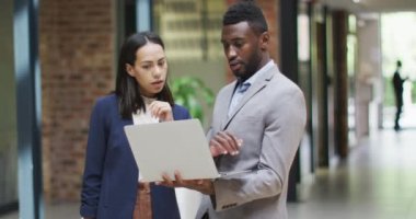 Modern ofiste dizüstü bilgisayar kullanarak birlikte çalışan iki mutlu iş adamı. iş ve işyeri.