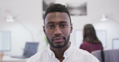 Modern ofiste kameraya bakan gülümseyen Afrikalı Amerikalı iş adamının portresi. iş ve işyeri.