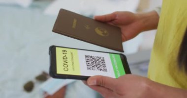 Pasaportu ve akıllı telefonu olan Asyalı bir kadının elleri ekranda seyahat için. covid 19 salgını sırasında seyahat hazırlığı.