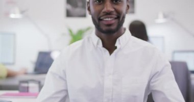 Modern ofiste kameraya bakan gülümseyen Afrikalı Amerikalı iş adamının portresi. iş ve işyeri.