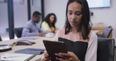 Modern ofiste kameraya bakarken tablet kullanan gülümseyen melez iş kadınının portresi. iş ve işyeri.
