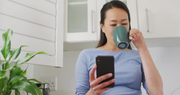 Šťastná Asijská Žena Pije Kávu Používá Smartphone Kuchyni Životní Styl — Stock video
