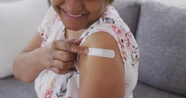 Улыбающаяся Африканская Пожилая Женщина Показывающая Повязку Руке После Ковидовой Вакцинации — стоковое видео