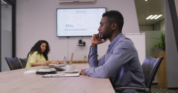 Африканський Американський Бізнесмен Сидить Столом Розмовляє Смартфоні Сучасному Офісі Роботі — стокове відео