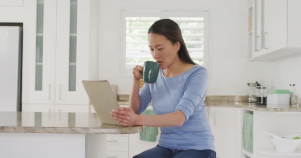 Šťastná Asiatka Sedící Stolu Pije Kávu Užívá Tabletu Kuchyni Životní — Stock video