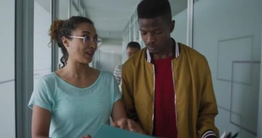 İş yeri koridorunda yürüyen ve konuşan çeşitli erkek ve kadın yaratıcı meslektaşınız kutlu olsun. Modern ofiste yaratıcı işler.