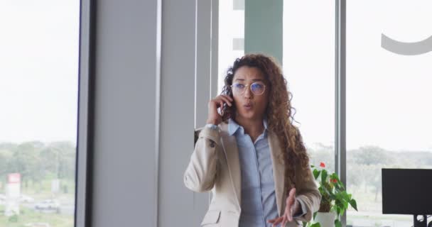 Mujer Negocios Biracial Sentada Junto Escritorio Hablando Teléfono Inteligente Interiores — Vídeos de Stock