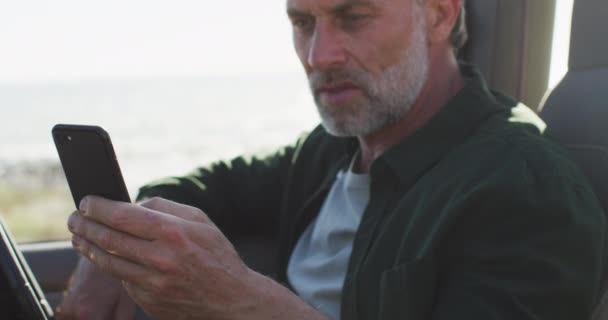 Güneşli Bir Günde Deniz Kenarında Akıllı Telefon Kullanarak Arabada Oturan — Stok video