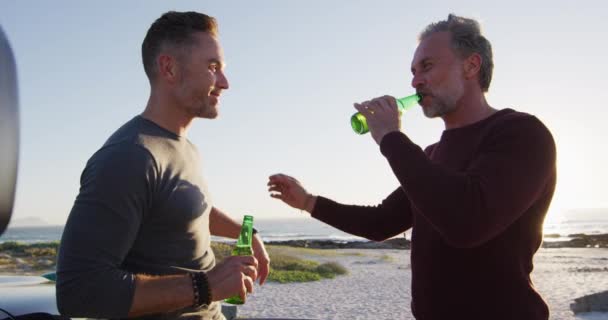 Szczęśliwy Biały Gej Mężczyzna Para Stoi Samochodzie Pijąc Butelki Piwa — Wideo stockowe