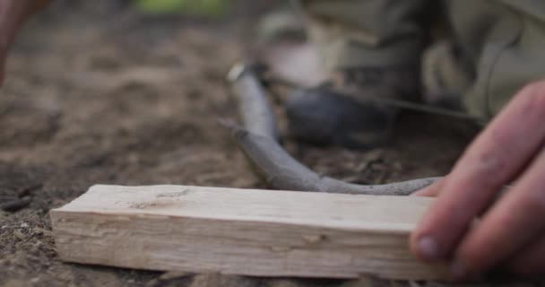 高加索男性幸存者的手 加上干土 准备野外营地的篝火板 自然求生者 — 图库视频影像