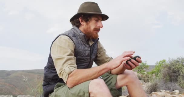 长胡子的高加索男性幸存者坐在山上 手持指南针 环顾四周 自然求生者 — 图库视频影像