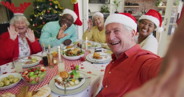 Heureux Amis Aînés Diversifiés Chapeaux Santa Prendre Selfie Agitant Table — Video