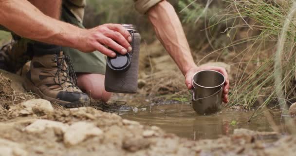 Caucasian Male Survivalist Scooping Water Stream Pouring Drinking Filter Bottle — Stock Video
