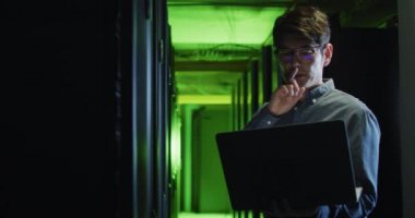 Asyalı erkek bilgisayar sunucusunu kontrol eden dizüstü bilgisayar teknisyeni. bilgi teknolojisi, veri işleme ve bilgisayar sunucuları.