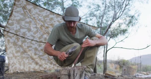 Homem Caucasiano Barbudo Sobrevivente Afiando Pau Com Facão Acampamento Deserto — Vídeo de Stock