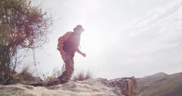 长胡子的高加索男性幸存者 背着背包在荒野中跳过岩石山峡谷 自然求生者 — 图库视频影像