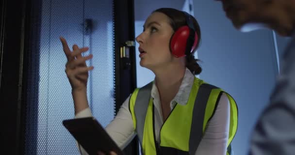 Zróżnicowana Kobieta Mężczyzna Technicy Noszący Słuchawki Pomocą Tabletu Sprawdzającego Serwer — Wideo stockowe