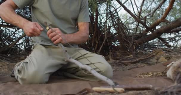 白人男性幸存者把绳子绑在树枝上 在荒野的营地里生火鞠躬 自然求生者 — 图库视频影像
