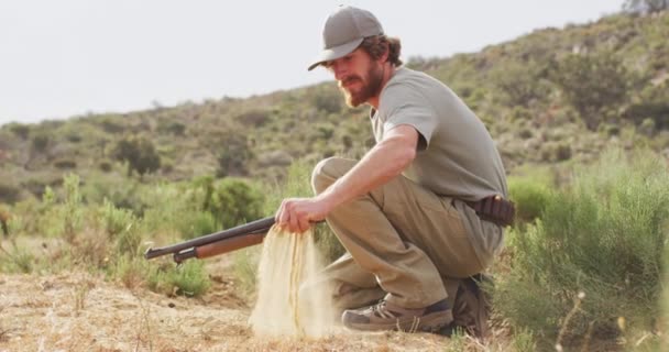 克奈灵的高加索男性幸存者手持猎枪 察看荒野的沙地 自然求生者 — 图库视频影像