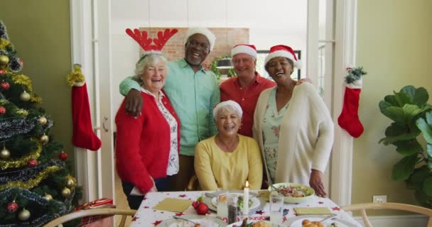 Retrato Diversos Amigos Mayores Sombreros Navidad Abrazando Sonriendo Mesa Cena — Vídeo de stock