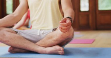 Yoga dersinde yoga nilüfer pozisyonunda oturan beyaz bir adam. Fitness, sağlıklı hobiler ve aktif yaşam tarzı. ovv