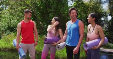 Dışarda yoga dersi için paspasları katlanmış gülümseyen çeşitli grupların portresi. fitness, sağlıklı hobiler ve açık havada aktif yaşam tarzı.
