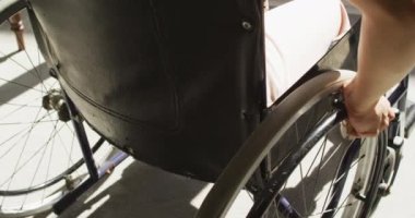 Dışarda güneşin altında tekerlekli sandalye kullanan engelli melez bir kadının orta kısmı. Fiziksel engelli refah ve ev hayatı.