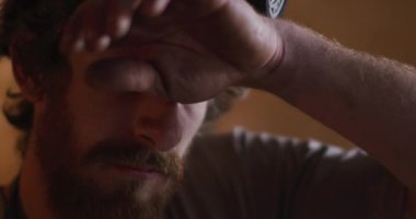 Atölyede solunum maskesi takan beyaz erkek demirci. Demirci ocağında küçük bir işletme ve işçilik..