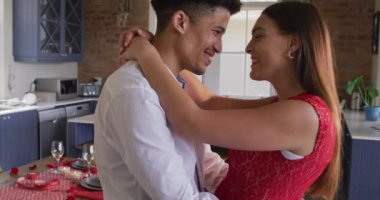 Sevgililer Günü 'nü evde dans ederek kutlayan melez çift. Sevgililer günü kutlaması, romantizm ve evde birlikte zaman geçirmek..