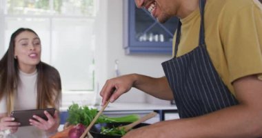 Birlikte yemek pişiren ve mutfakta gülen mutlu çift. Kaliteli zaman, evde birlikte dinlenmek..