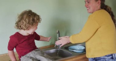 Mutfakta elini yıkayan Kafkas anne ve oğlu kutlu olsun. Kırsal kesimdeki organik çiftlikte çiftçilik, sağlıklı yaşam tarzı..