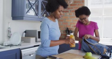 Mutlu Afro-Amerikan anne ve kızı okul için öğle yemeği hazırlıyor. evde aile hayatı ve kaliteli aile zamanı.