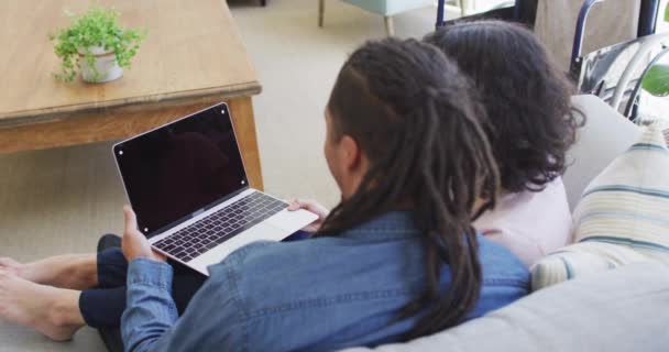Feliz Casal Biracial Sentado Sofá Usando Laptop Sala Estar Espaço — Vídeo de Stock