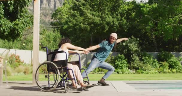 Счастливая Расовая Женщина Инвалидной Коляске Танцует Саду Улыбающимся Мужчиной Партнером — стоковое видео