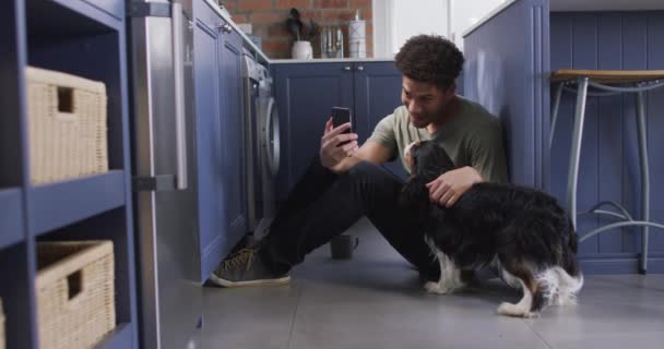 Homem Biracial Feliz Sentado Chão Cozinha Com Seu Cão Estimação — Vídeo de Stock