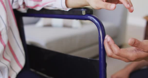Biracial Γυναίκα Αναπηρική Καρέκλα Κρατώντας Χέρι Αρσενικό Σύντροφο Στο Σαλόνι — Αρχείο Βίντεο
