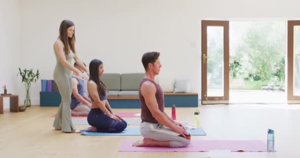 在女教员的帮助下 不同的小组在课堂上练习瑜伽 跪在垫子上 健康的爱好和积极的生活方式 — 图库视频影像