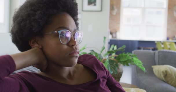悲伤的非洲裔美国少女坐在客厅的沙发上 家庭生活 在家里消磨时间 — 图库视频影像
