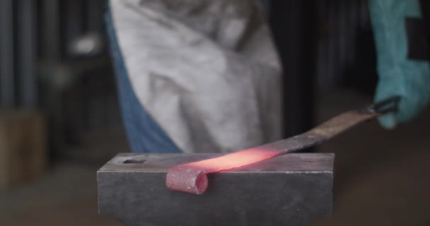 在高加索男性铁匠的中间 戴着安全眼镜 在铁锤上锤击着炽热的金属工具 小生意和锻造铁匠的工艺 — 图库视频影像