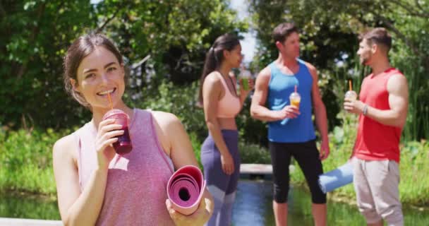 Mujer Caucásica Sonriente Bebiendo Bebida Saludable Con Diversos Grupos Hablando — Vídeos de Stock