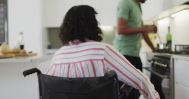 Biracial Γυναίκα Αναπηρική Καρέκλα Μιλάμε Χαμογελαστό Αρσενικό Σύντροφο Προετοιμασία Των — Αρχείο Βίντεο