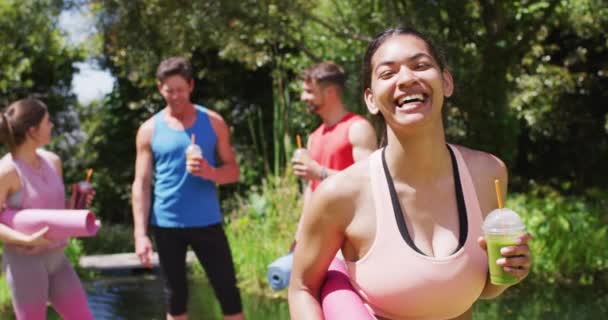 Glimlachende Biraciale Vrouw Drinken Gezondheidsdrankje Met Diverse Groep Praten Yoga — Stockvideo