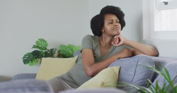 Uma Mulher Afro Americana Atenciosa Sentada Sofá Olhar Pela Janela — Vídeo de Stock