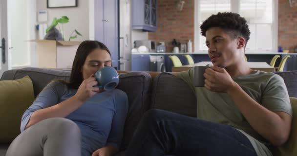 Szczęśliwa Para Dwurasowa Siedzi Kanapie Salonie Pije Kawę Jakość Czasu — Wideo stockowe