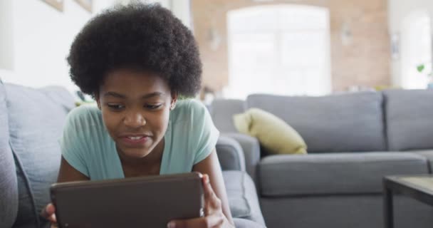 Gelukkig Afrikaans Amerikaans Tienermeisje Liggend Bank Met Behulp Van Tablet — Stockvideo